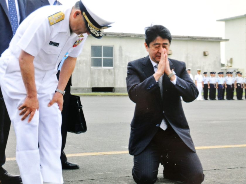 硫黄島の滑走路にひざまずき戦没者に哀悼の意を表す安倍元首相の写真
